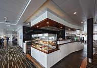 Moderne Cafeteria mit Glasvitrine und gemütlicher Atmosphäre.