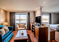 Helles Wohnzimmer mit Sofa, Sessel und Wasserblick.