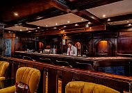 Elegante Bar mit Holzmöbeln und gedämpfter, gemütlicher Beleuchtung.
