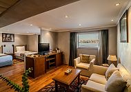 Gemütliches Hotelzimmer mit Doppelbett und einladender Sitzecke.