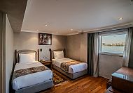 Gemütliches Doppelzimmer mit Flussblick und zwei Einzelbetten.