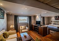 Gemütliches Hotelzimmer mit Sofa, Bett und Fernseher.