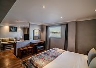 Gemütliches Hotelzimmer mit Doppelbett und Sitzecke.