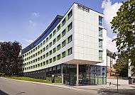 Moderne Hotelaußenansicht bei sonnigem Wetter.