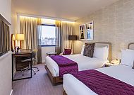 Modernes Hotelzimmer mit zwei Betten und gemütlicher Atmosphäre.