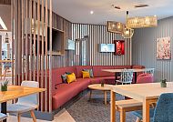 Moderne Lounge mit roten Sofas, Holzmöbeln und gemütlicher Atmosphäre.