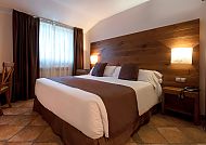 Gemütliches Hotelzimmer mit Doppelbett und Holzdekor.