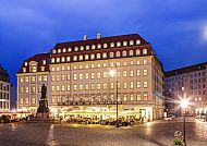 Außenansicht des beleuchteten Hotels am Abend, entspannte Stimmung.