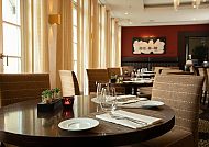 Elegantes Restaurant mit gedeckten Tischen und warmer Atmosphäre.