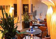 Gemütliche Hotelbar mit Pflanzen und stilvoller Beleuchtung.