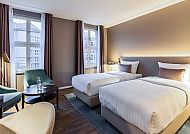 Modernes Hotelzimmer mit zwei Betten und gemütlicher Atmosphäre.
