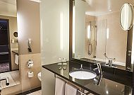 Modernes Hotelbad mit Spiegel, Waschbecken und Dusche.