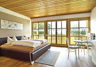 Haus Talblick, Helles, gemütliches Hotelzimmer mit Holzelementen und Balkon.