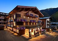 Panther Aussen Sommer, Hotel Panther'A bei Sonnenuntergang, umgeben von Bergen.