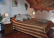 , Gemütliches Zimmer im Hotel Vittoria mit rustikalem Charme., Gemütliches Zimmer im Hotel Vittoria mit Dachschräge und Dekor.