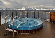Pool an Deck der MS Midnatsol mit Blick auf verschneite Berge