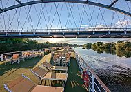 Sonnendeck vpn MS Casanova, Sonnendeck der MS Casanova unter einer Brücke bei Sonnenuntergang., Entspanntes Sonnendeck auf der MS Casanova unter einer Brücke.