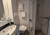 Badezimmer auf MS Olympia, Modernes Badezimmer auf der MS Olympia, stilvoll und kompakt., Modernes Badezimmer auf der MS Olympia mit Dusche und Waschbecken.