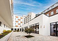 Novotel Münster City, Moderner Innenhof des Novotel Münster City mit klarem Himmel.