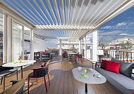 Moderne Hotelterrasse mit stilvoller Einrichtung und Blick auf die Stadt