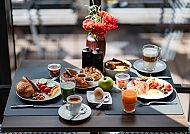 Frühstück im AMERON Hamburg Hotel Speicherstadt mit Blumenarrangement.