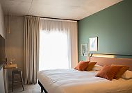 Modernes Hotelzimmer mit gemütlichem Doppelbett und stilvollem Design