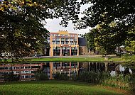 Amrâth Hotel Alkmaar-Außenansicht, Amrâth Hotel Alkmaar mit idyllischem Teich und grüner Umgebung., Amrâth Hotel Alkmaar mit Spiegelung im Wasser, umgeben von Bäumen.