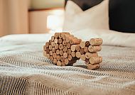 BE BIO - be natural, Be Bio - Be Natural: Zimmerdetail mit Kork-Deko in Tönning., Korken-Deko auf Bett im Hotel Be Bio - be natural, Tönning.