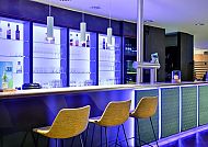 Moderne Hotelbar mit stilvollem Ambiente und blauer Beleuchtung.