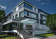 , Hotel West Baltic Resort Wellness & Spa, moderne Außenansicht., Modernes Hotelgebäude mit Glasfront und Treppe im Grünen.