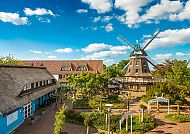 Landhotel Lewitz Mühle, Außenansicht, Landhotel Lewitz Mühle mit Windmühle und blühendem Garten., Landhotel Lewitz Mühle mit idyllischem Mühlenhof und blauem Himmel.