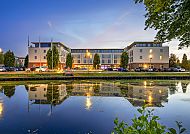 Hotelansicht, Best Western Plus Hotel Papenburg bei Abenddämmerung am Wasser., Best Western Plus Hotel Papenburg am Abend, Spiegelung im Wasser.