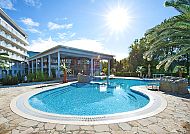 Sonniger Poolbereich im Hotel Ikar Plaza mit Palmen und klarem Himmel