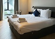Hotel Twenty-Three, Zimmerbeispiel, Modernes Hotelzimmer mit gemütlichem Doppelbett und Fensterblick.