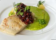 Villa Esplanade mit Aurora, Kulinarik, Gourmetgericht mit Fischfilet und grünem Püree, kunstvoll angerichtet.