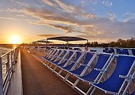 , Sonnenuntergang auf dem Außendeck der MS Lisabelle mit blauen Liegestühlen., Sonnenuntergang auf dem Außendeck der MS Lisabelle mit blauen Liegen.