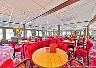 MS VistaRio unterwegs auf dem Rhein, Eleganter Lounge-Bereich auf der MS VISTARIO mit roten Sesseln., Eleganter Innenraum der MS VISTARIO mit roten Sesseln.