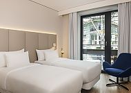 NH Leipzig Zentrum, Zimmerbeispiel, Modernes Hotelzimmer im NH Leipzig Zentrum mit zwei Betten.