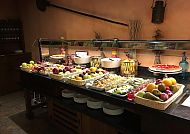 Buffet mit frischem Obst und Salaten in gemütlichem Restaurant.