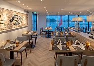 Elegantes Restaurant mit gedeckten Tischen und gemütlicher Atmosphäre.