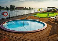 Sonnendeck mit Whirlpool und Flussblick bei entspannter Atmosphäre.